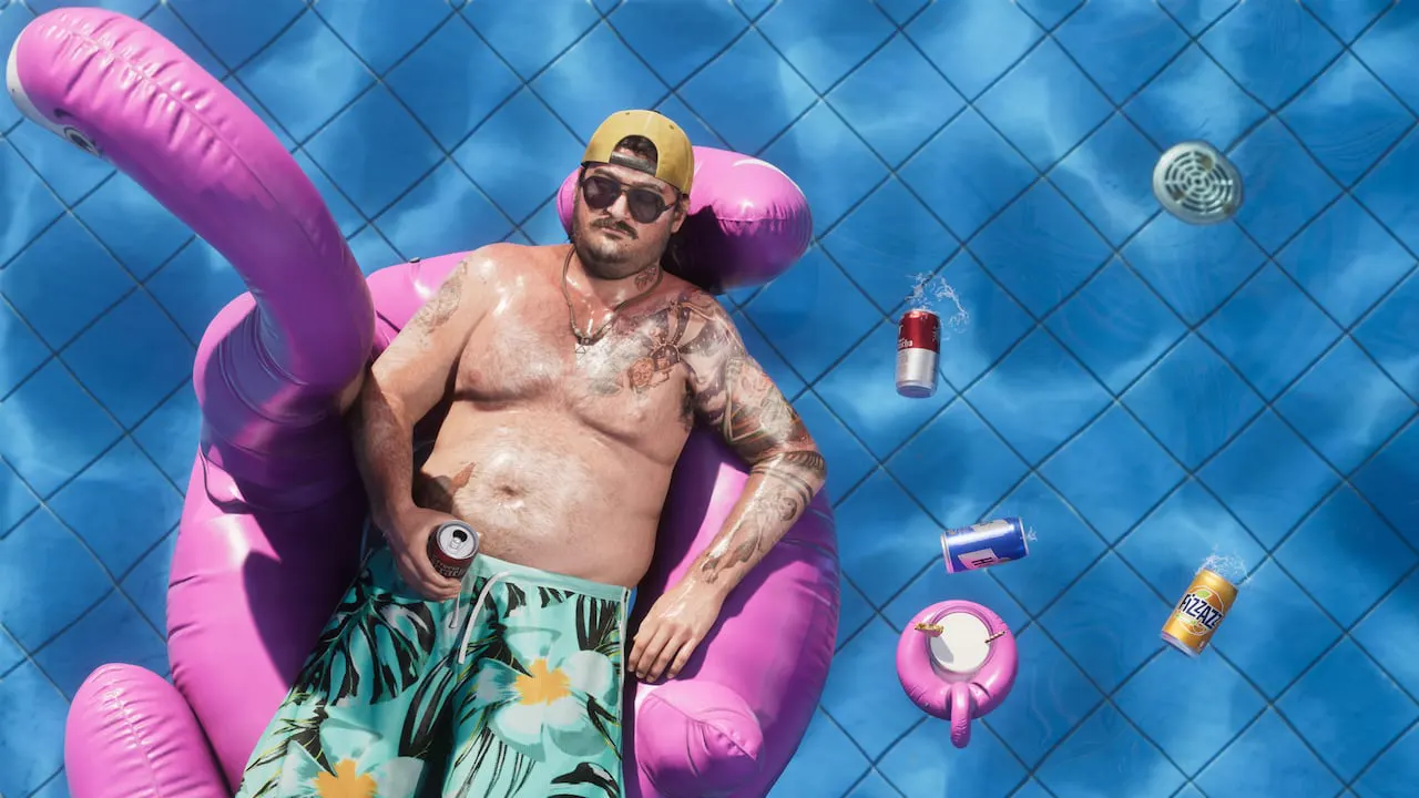 Cal recostado sobre un flotador de flamingo en una piscina rodeado de latas flotantes.